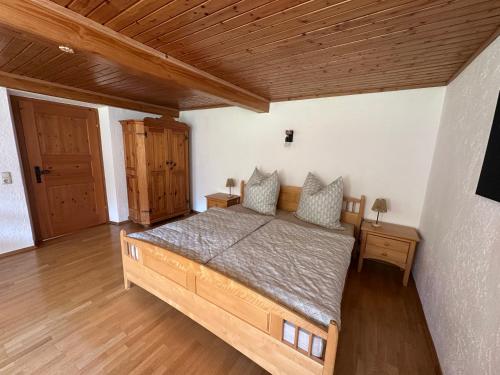 a bedroom with a bed and a wooden ceiling at Ferienwohnung Beim Straßer in Flintsbach