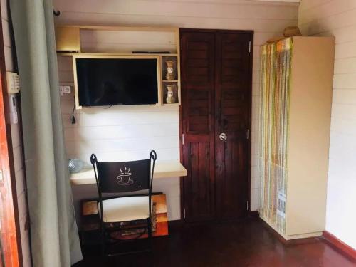 a room with a chair and a television and a door at Charming apartment in Albion with shared pool, 20.3 m² in Albion