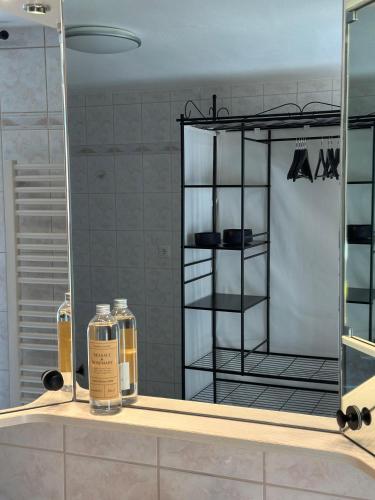 a bathroom mirror with two bottles on a sink at Ferienwohnung Beim Straßer in Flintsbach