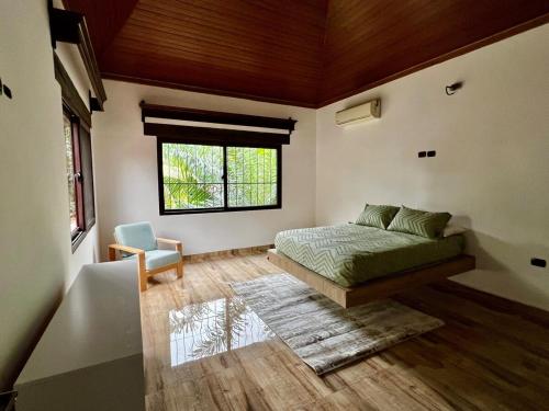 een slaapkamer met een bed en een raam bij Private Guesthouse near Airport in San Pedro Sula