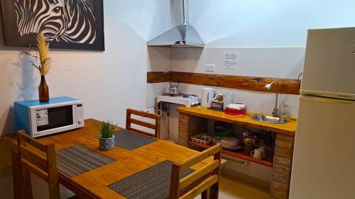 a small kitchen with a table and a microwave at departamento por dia ruta 41 3 in Los Antiguos