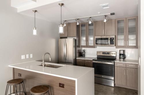 a kitchen with stainless steel appliances and wooden cabinets at Kasa Downtown Austin in Austin