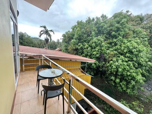 a balcony with two chairs and a table at PROpaganda Guest House in Thongsala