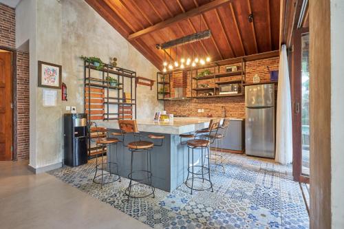 チャングーにあるCasa Ola Villa Pererenanのバースツール付きの島のあるキッチン