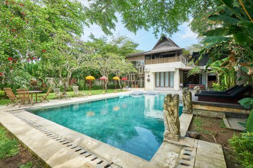 a swimming pool in front of a house at Casa Ola Villa Pererenan in Canggu
