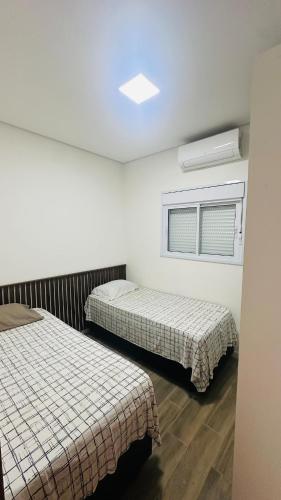 une chambre avec deux lits et une fenêtre dans l'établissement Casa com piscina - Costa do Sol, à Bertioga