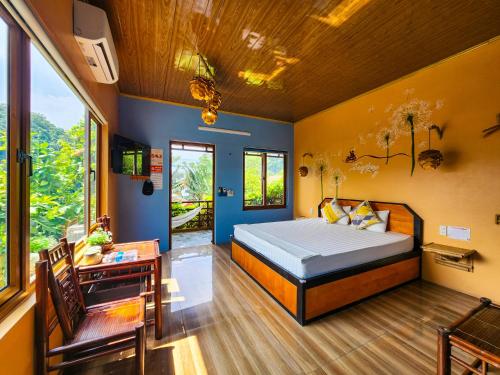 a bedroom with a bed and a desk andwindows at Trang An Village Homestay in Ninh Binh