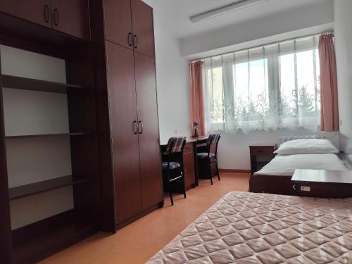 a bedroom with a bed and a desk and a window at Dom Studenta nr 2 in Siedlce