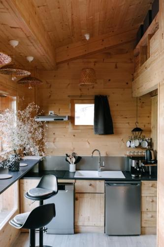 una cucina con pareti e ripiani in legno di Charming Tiny House a LʼIsle-sur-la-Sorgue