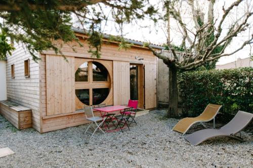 een kleine houten hut met stoelen en een tafel bij Charming Tiny House in LʼIsle-sur-la-Sorgue