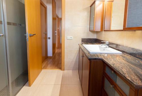 eine kleine Küche mit einem Waschbecken und einem Flur in der Unterkunft Catalunya Casas Cozy beach town villa for 8 - no car necessary! in Pineda de Mar