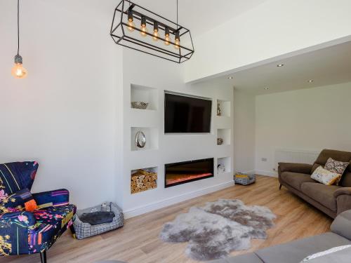 a living room with a couch and a fireplace at Sea Breezes in Anderby