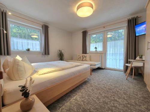 una camera da letto con un letto, un divano e finestre di Appartement Skorpion a Sölden