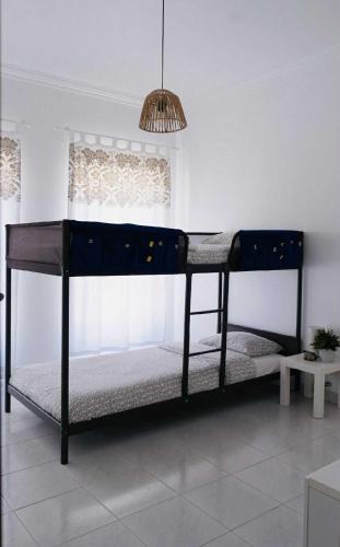 een zwart stapelbed in een kamer met een raam bij Maresia Baleal House in Baleal