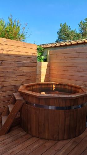 Le Lodge de Riorges في Riorges: حوض خشبي موضوع على سطح خشبي