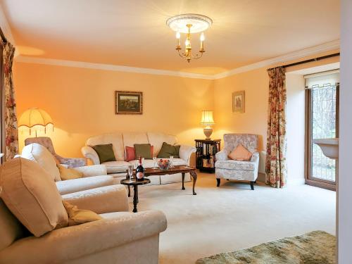 a living room with couches and chairs and a chandelier at Holly Barn in Selattyn