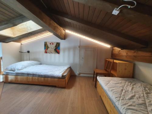 a bedroom with two beds and a table in a attic at LAAX Homes - Maighels 8-9 in Laax-Murschetg