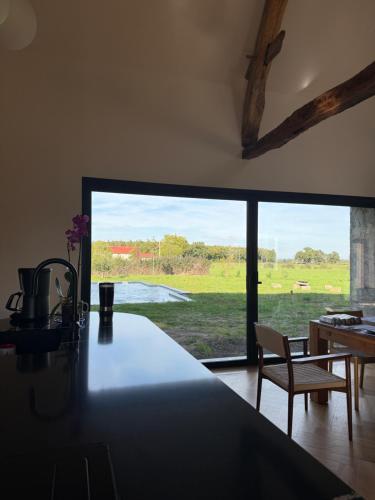 a kitchen with a large window with a view of a field at Le Secret in Lusigny