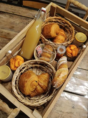 Les Deux Sources في Tigné: صندوق من الخبز والمعجنات وزجاجة من الحليب
