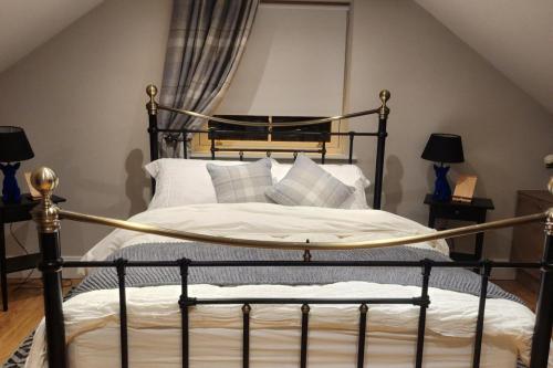 a bedroom with a black bed with white pillows at Ravensdale Retreat Dundalk in Dundalk
