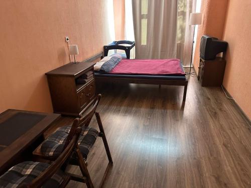 a room with two beds and a desk and a television at EBU 28 in Rīga