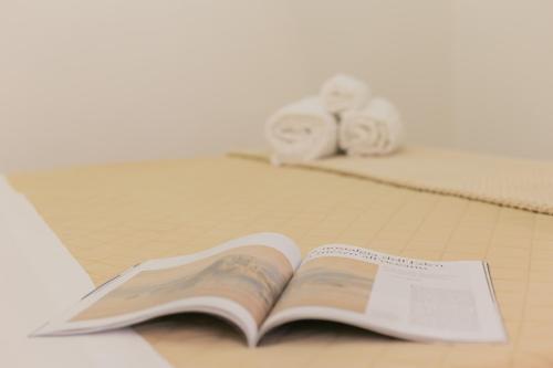 Un libro abierto sobre una mesa con dos rollos de papel higiénico. en La Casa di Ninetta - Boutique Stay, en Monopoli