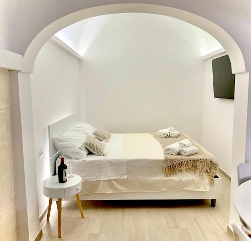 a white bedroom with a bed and a table at La Casa di Ninetta - Boutique Stay in Monopoli