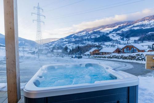 a jacuzzi tub with snow on the ground at Alpenchalét Alpakablick in Sankt Lorenzen ob Murau