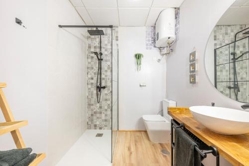Un baño blanco con lavabo y ducha. en Casa Libertad Estepona, en Estepona