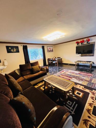 a living room with a couch and a table at Costa Green Garden- Luxury 4 bedroom bungalow Mountain view in Kodaikānāl