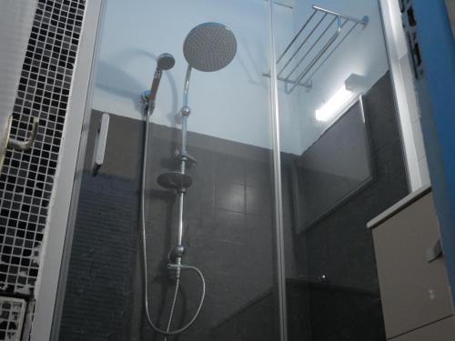 una ducha con puerta de cristal en un baño en STUDIO FACE MARINA, en Saint-François