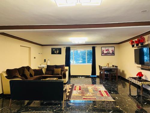 a living room with a couch and a table at Costa Green Garden- Luxury 4 bedroom bungalow Mountain view in Kodaikānāl