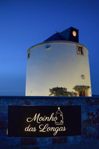 a sign for a restaurant in front of a tower at Moinho das Longas in Montelavar