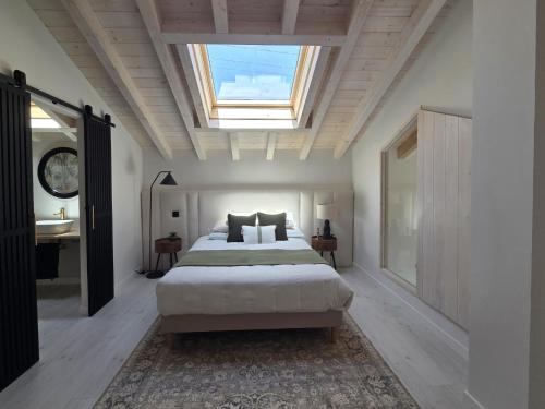 a bedroom with a large bed and a skylight at La Casuca del Olivo - casa con jardín cerca de Cabárceno y Santander in Ceceñas