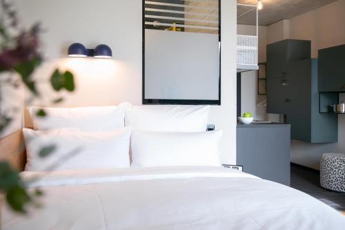 ボーフムにあるSTAYERY Bochum Ehrenfeldの白いシーツと枕が備わったベッドのある寝室