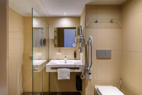 a bathroom with a sink and a shower at Mercure Hotel Hannover City in Hannover