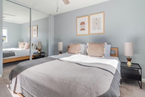 a bedroom with a large bed with mirrored walls at Blueground Edgewood Park pool nr Edgewood Park SFO-2060 in Redwood City