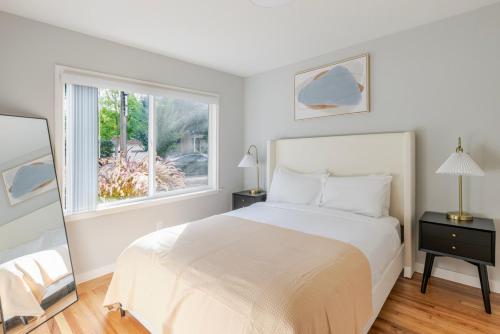 a white bedroom with a bed and a window at Blueground Menlo Park view nr Menlo Park Park SFO-1999 in Menlo Park