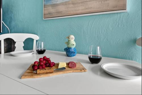 a table with a cutting board and two glasses of wine at Tiki Time - Daytona Beach Oceanfront Condo! in Daytona Beach