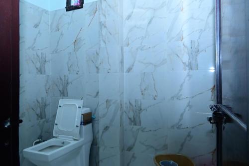 ĀzamgarhにあるWhite stay houseの白い大理石の壁、トイレ付きのバスルーム