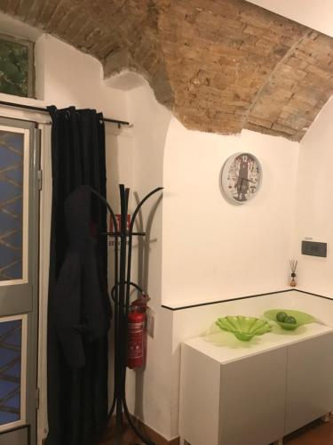 フォリーニョにあるAlloggio turistico Via del Liceo 17, Foligno, Umbriaのテーブルと時計付きの部屋