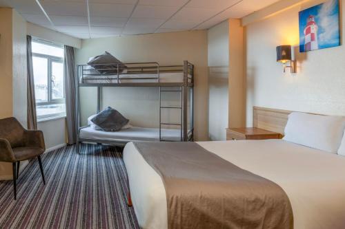 a hotel room with a bed and bunk beds at The Grand Burstin Hotel in Folkestone