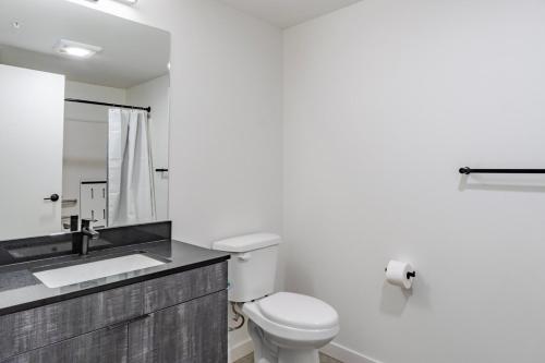 a white bathroom with a toilet and a sink at Blueground New Tacoma balcony nr Museum SEA-954 in Tacoma