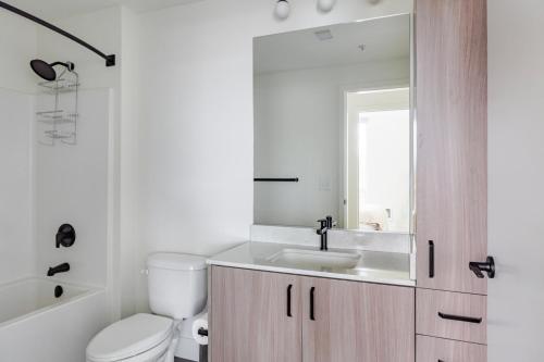 a bathroom with a toilet and a sink and a mirror at Blueground Lynnwood view nr Lynndale Park SEA-950 in Lynnwood
