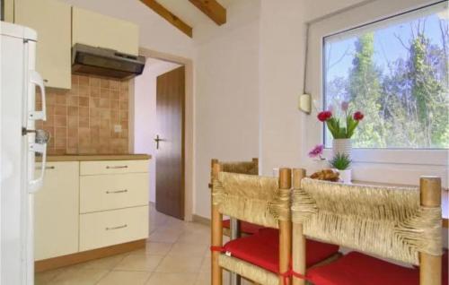a kitchen with a table and chairs and a window at Beautiful Apartment In Lukoran With Wifi in Lukoran