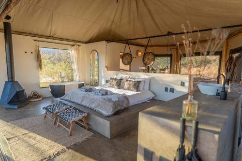 a bedroom with a bed and a tub in a tent at Sasi Bush Lodge- Exclusive Use Luxury Tented Safari Lodge in Bergville