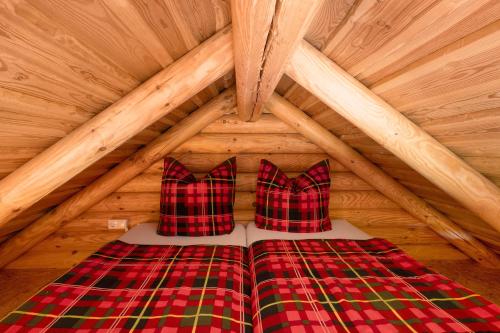 a bed with two pillows in a wooden attic at Chalet am See in Bad Brambach