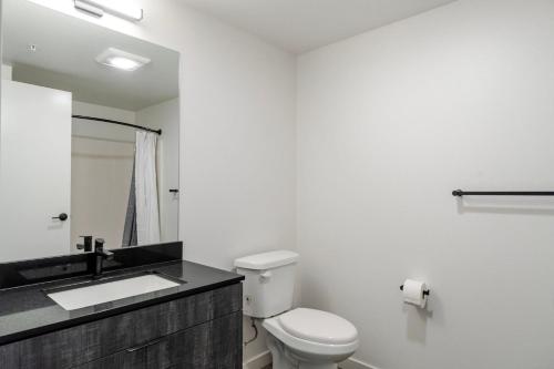 une salle de bain blanche avec toilettes et lavabo dans l'établissement Blueground New Tacoma balcony nr Union Station SEA-955, à Tacoma