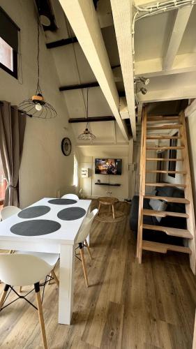 a room with a table and chairs and a bunk bed at Chalet Le Capéna Lac de Payolle in Campan
