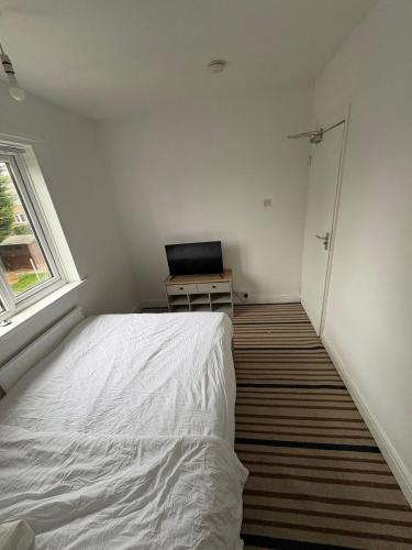 Un dormitorio con una cama y una computadora portátil en un escritorio. en WOLVES Stay, en Wolverhampton